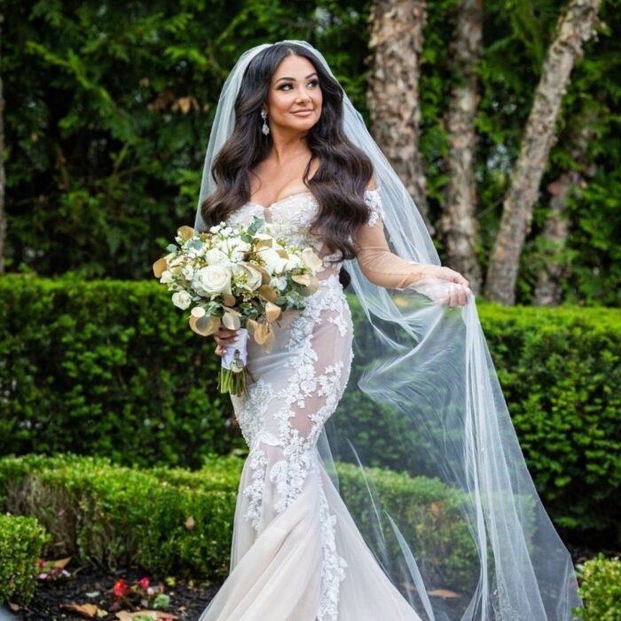 bride standing in a green garden