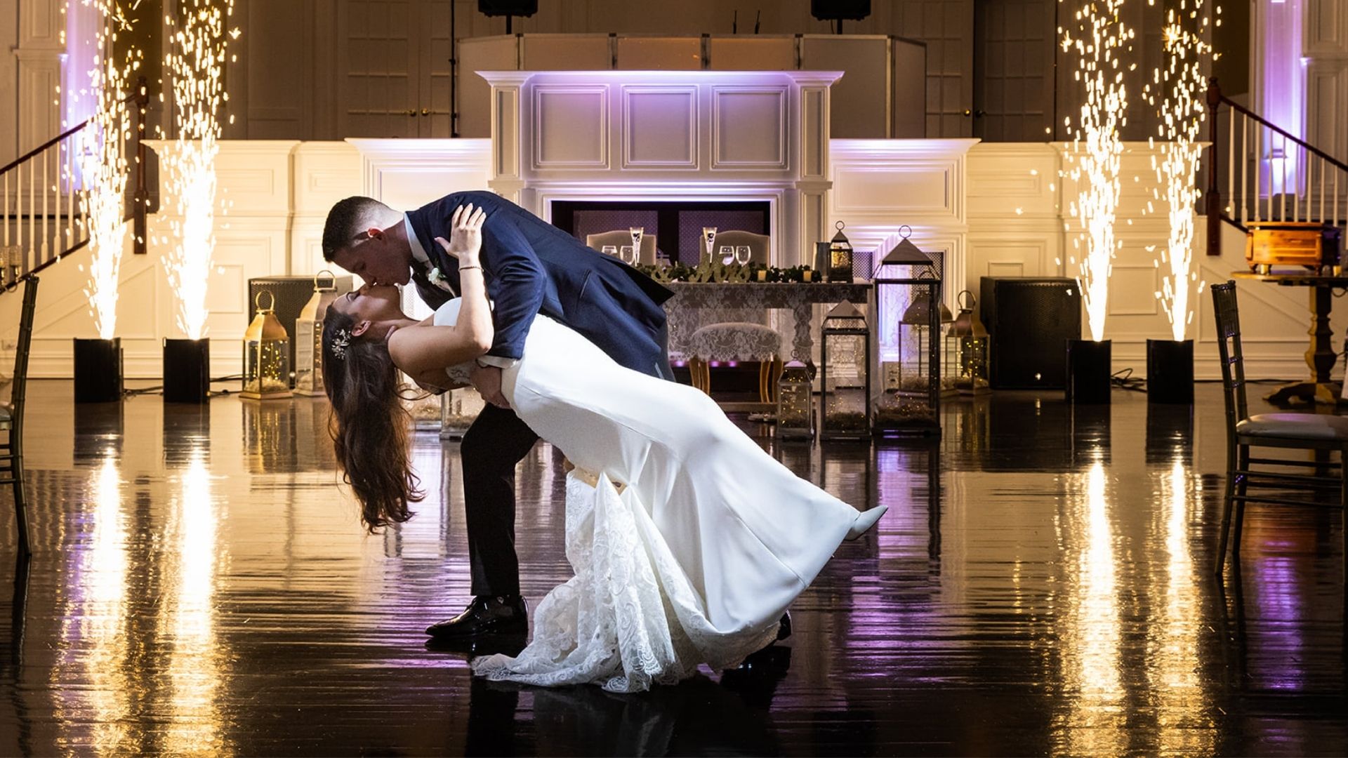 bride and groom dancing with pyrotechnics going off in the background
